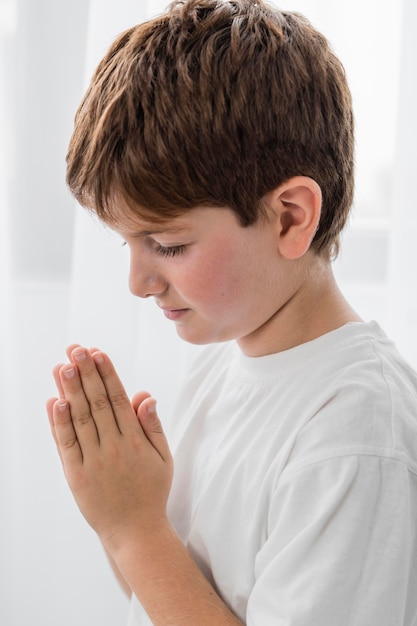 Free photo side view of boy praying