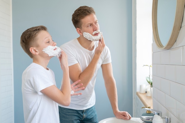 Side view boys using shaving foam