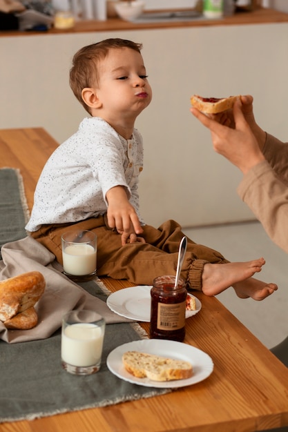 Free photo side view brothers with food at home