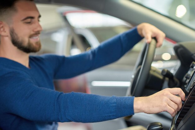 Side view of brunette man with beard sitting in car