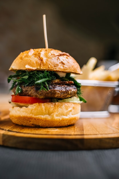 Side view of burger with meat cutlet on a wooden board