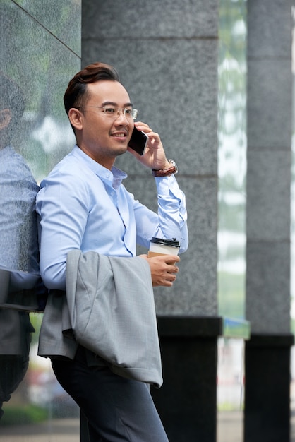 Free photo side view of businessman having phone talk outdoors on a summer day