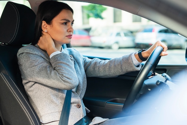 Side view of businesswoman having neck pain in the car