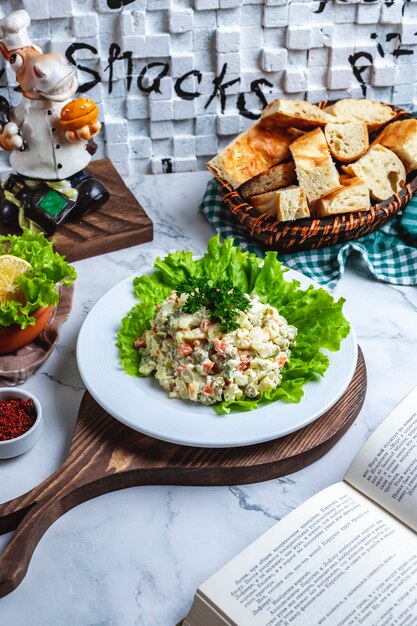 Side view capital salad on lettuce with bread