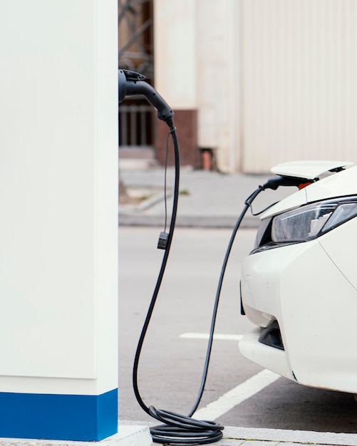 Free photo side view of car being charged at electric vehicle charging station