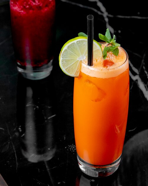 Side view carrot juice with a slice of lime