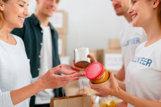 Side view of cheerful volunteers giving out food donations