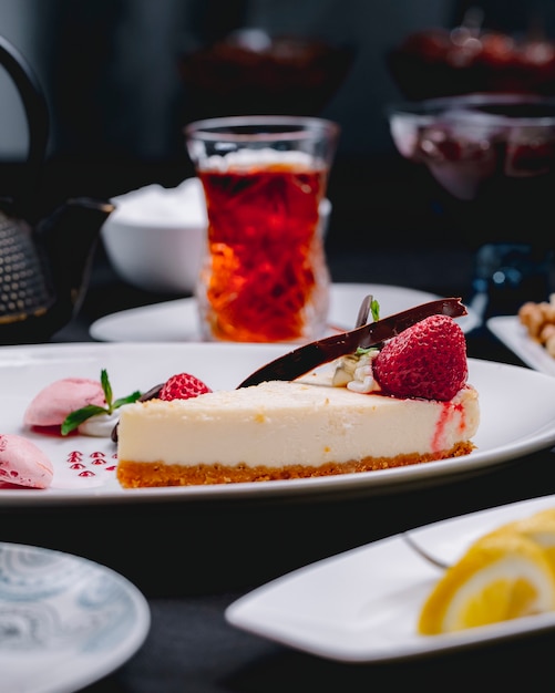 Free photo side view of cheesecake decorated with fresh strawberries on a white plate