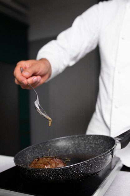 Side view chef cooking meat