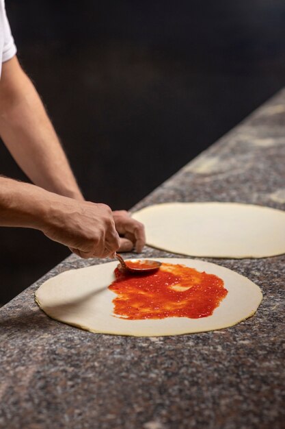 Side view chef preparing pizza