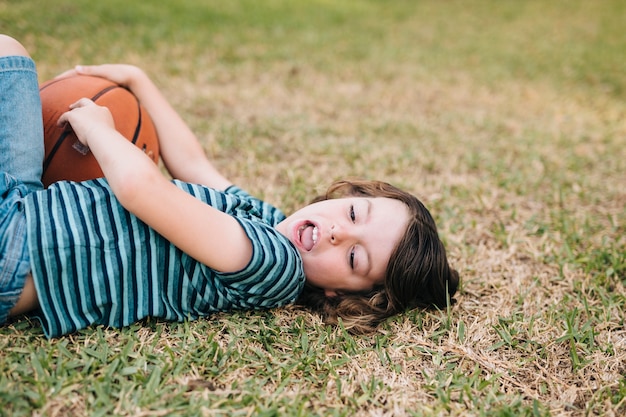 Free photo side view of child lying in grass