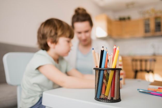 Side view of child and tutor at home taking a class