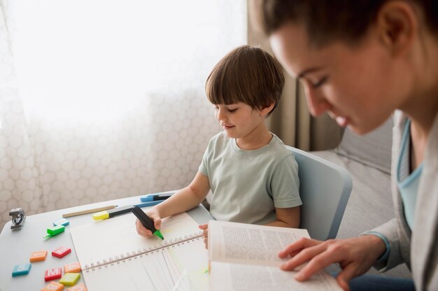 Side view of child and tutor at home