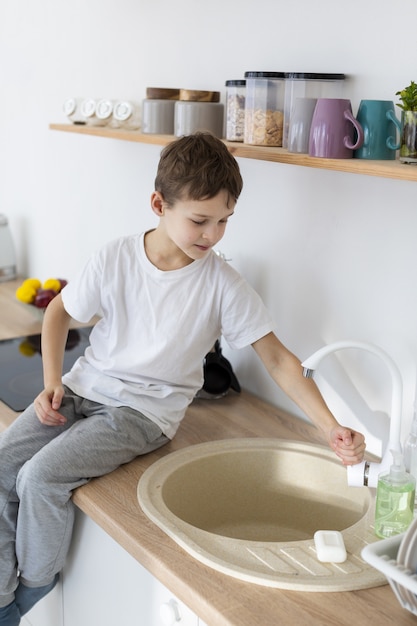 Side view of child washing his hands