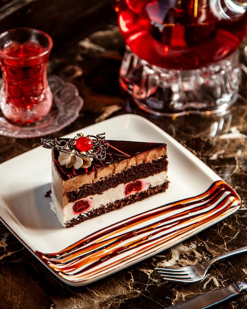 Side view of chocolate cake with cherries on platter