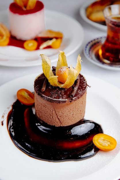 Free photo side view of chocolate cheesecake topped with kumquat