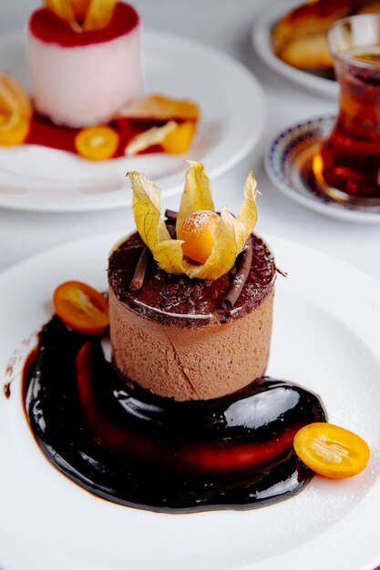 Side view of chocolate cheesecake topped with kumquat