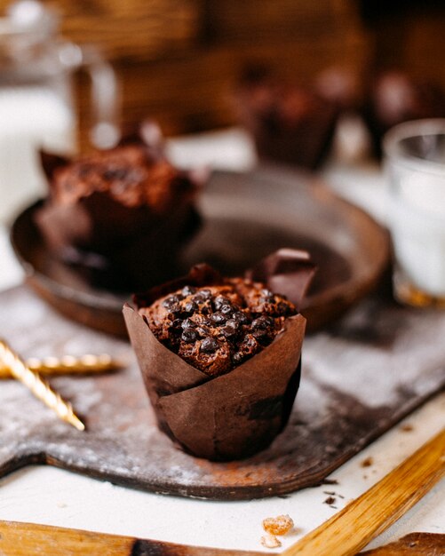 Side view of chocolate muffin on a wooden cutting board