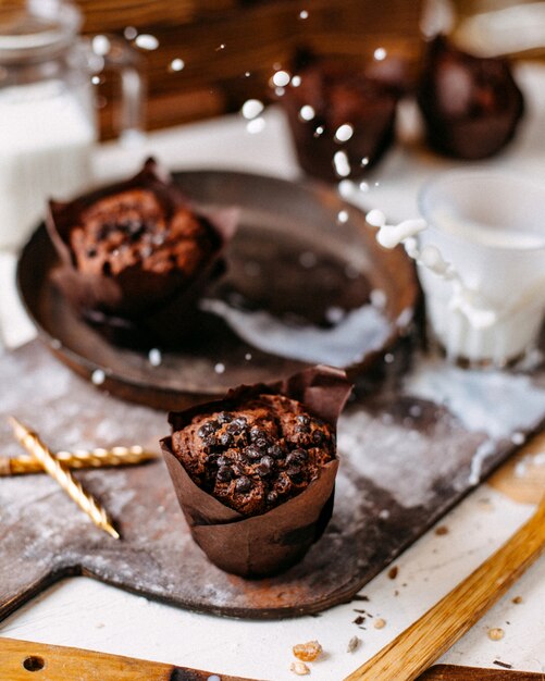 Side view of chocolate muffin on a wooden cutting board