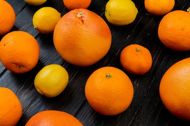 Side view of citrus fruits as orange tangerine lemon on wooden background