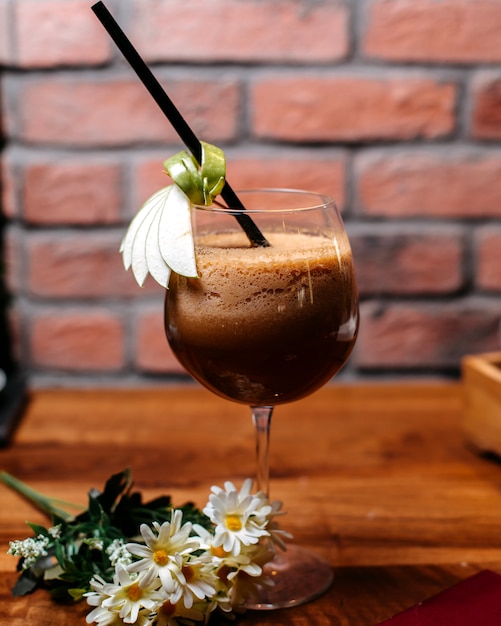 Side view of coffee cocktail with liquer and cream on a wooden table