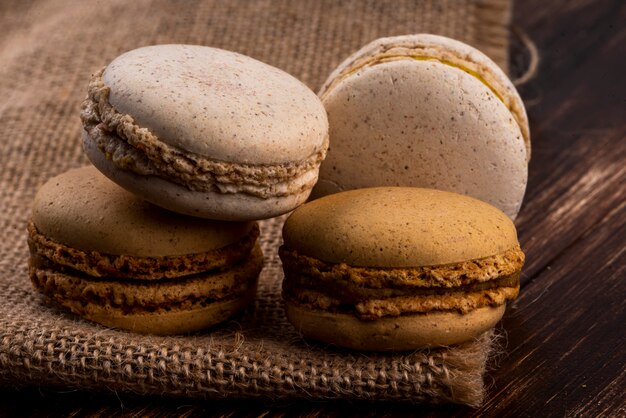 Side view of cookie sandwiches on sackcloth and wooden background