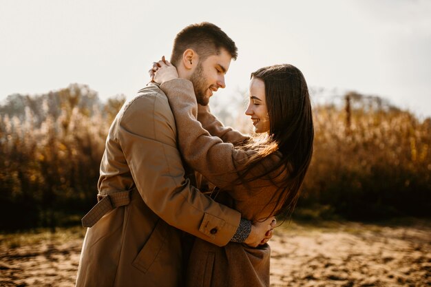 Side view couple holding each other