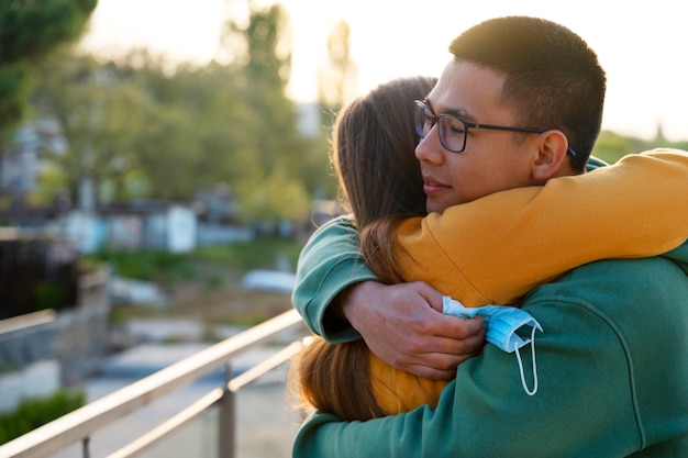 Side view couple hugging outdoors