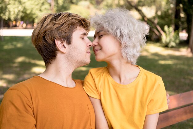 Side view of couple leaning in for a kiss while in the park