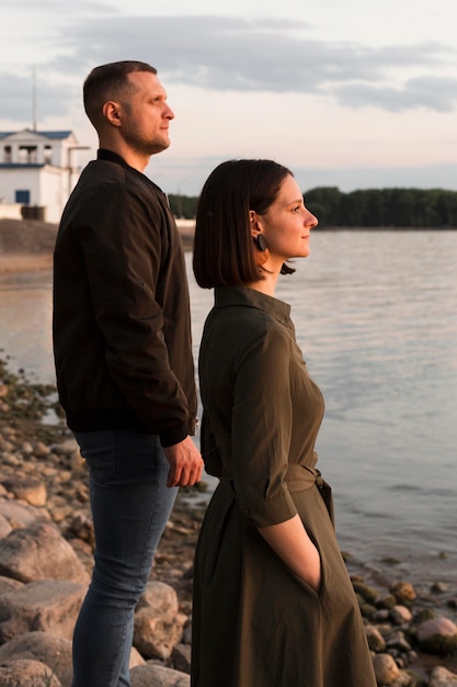 Side view couple looking at sea