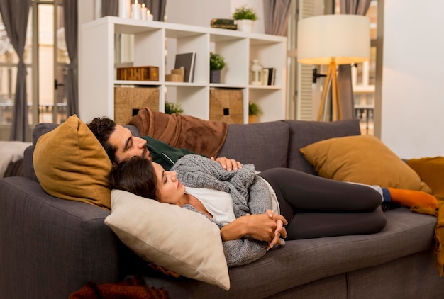 Side view couple lying on the sofa