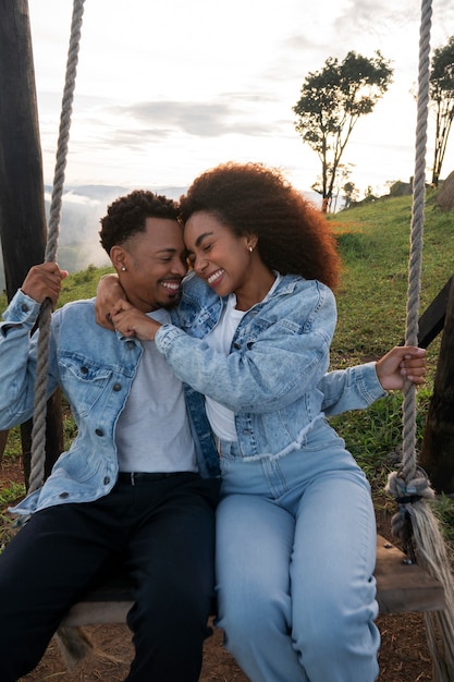 Side view couple on swing outdoors