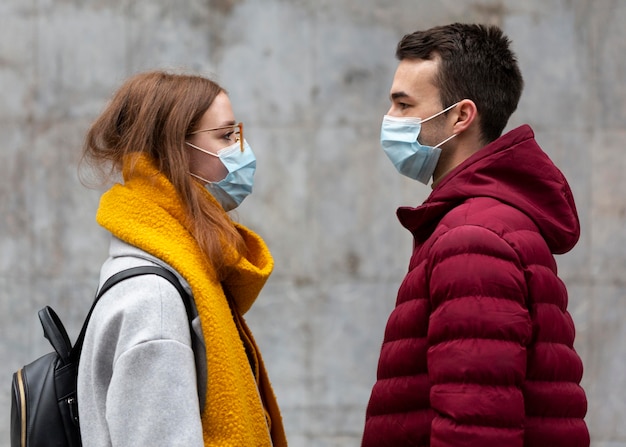 Side view of couple wearing medical masks