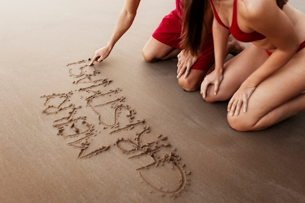 Side view couple writing in sand