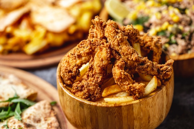 Free photo side view crispy fried chicken tenders with french fries