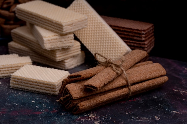 Free photo side view of crispy sticks tied with rope and waffles on dark