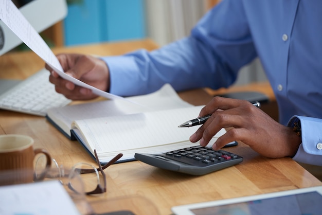 Side view of cropped man working on financial report