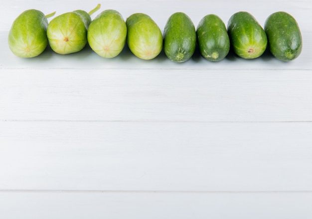 Side view of cucumbers on wooden surface with copy space