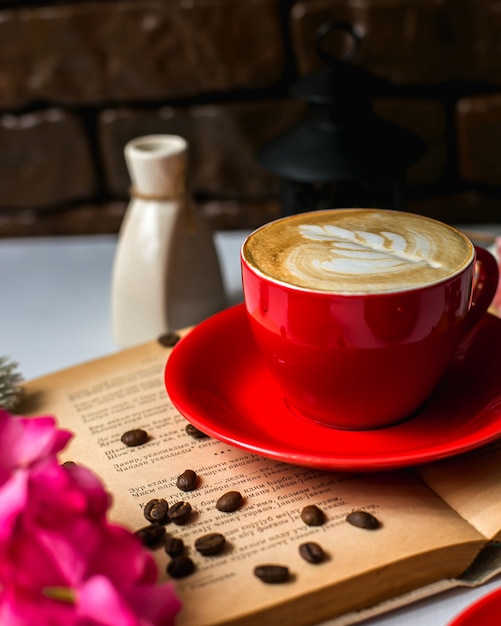 Side view of a cup of latte and coffee beans on the table