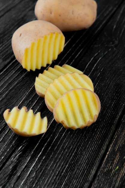 Side view of cut and sliced potato on wooden background with copy space