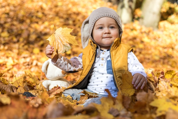 Free photo side view cute baby playing with leaves