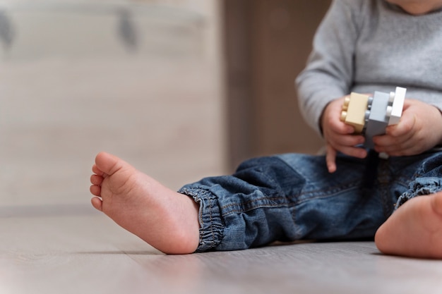 Free photo side view cute kid with toy on floor