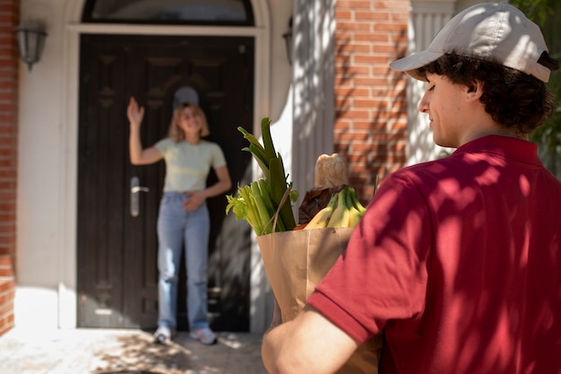 Free photo side view delivery man with groceries