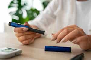 Free photo side view diabetic woman checking her glucose level