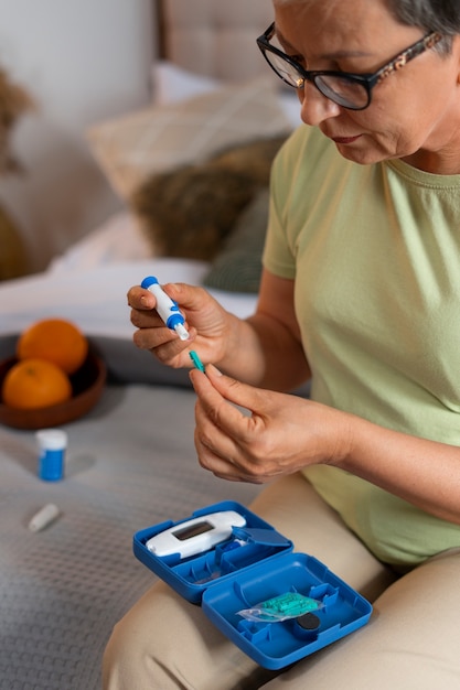 Free photo side view diabetic woman checking her glucose level