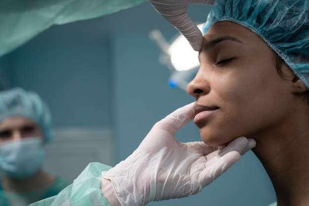 Side view doctor checking patient before rhinoplasty