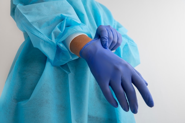 Free photo side view doctor putting on glove