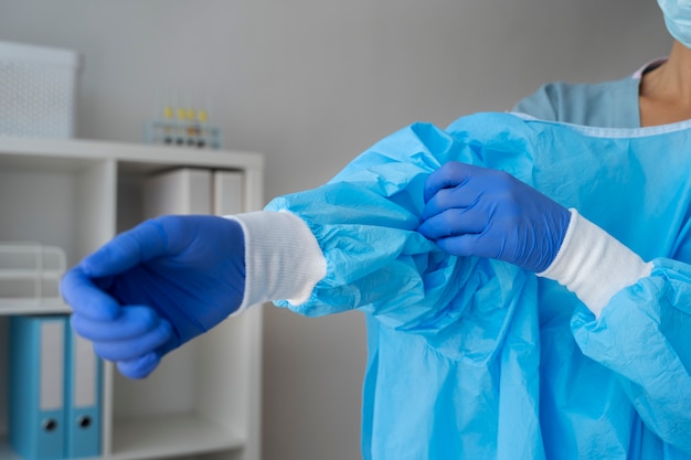 Free Photo side view doctor putting on medical gown