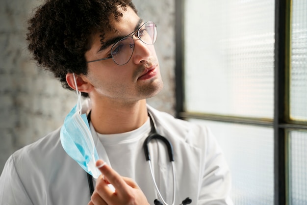 Side view doctor taking mask off