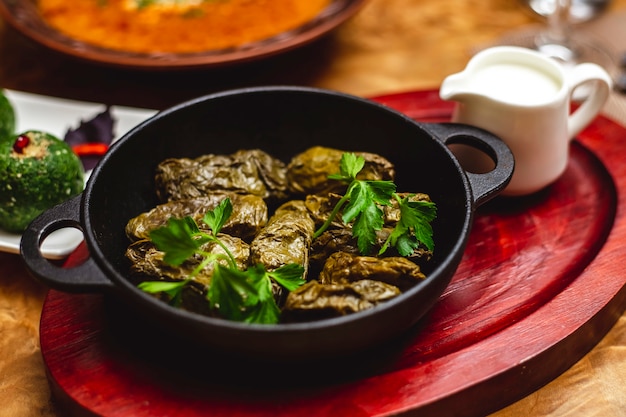 Side view dolma stuffed grape leaves with ground meat onion and greens